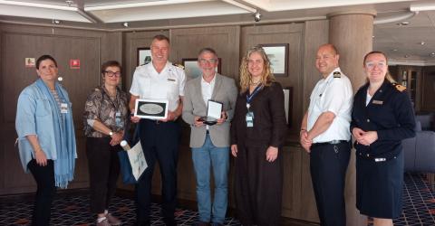 El presidente de la APS, César Díaz (4º por la izquierda), entrega una metopa al capitán del barco, junto a parte de la tripulación y representantes de Santander Cruise Deluxe